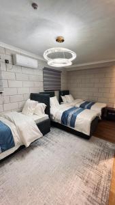 ein Schlafzimmer mit zwei Betten und einem Kronleuchter in der Unterkunft Temirlan hotel in Schymkent