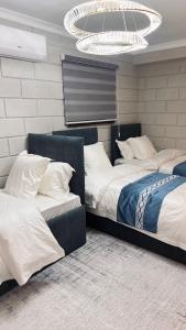 2 Betten in einem Schlafzimmer mit Kronleuchter in der Unterkunft Temirlan hotel in Schymkent