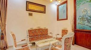 a living room with a couch and a table and chairs at OYO 92990 Nena Kostel Syariah in Padang