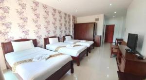 Ban Khlong Chi LatDoungta Anda Hotel Krabi的有三张床和一台电视的酒店房间