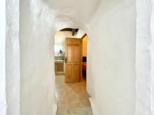 un corridoio con una porta su un muro bianco di Cave Houses Ed, Yara and Nadieh with PRM facilities a Margen de Abajo