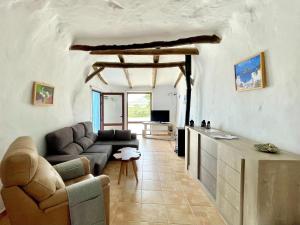 un soggiorno con un divano e un tavolo di Cave Houses Ed, Yara and Nadieh with PRM facilities a Margen de Abajo