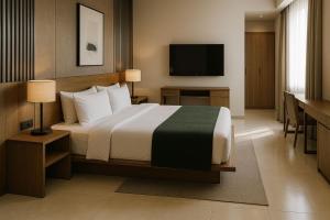 ein Hotelzimmer mit einem Bett und einem Flachbildfernseher in der Unterkunft Remsyatan Viuse in Abuja