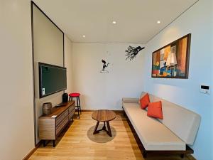 a living room with a couch and a tv at Mandala Hotel & Resort 5 Star in Mui Ne +80 photos