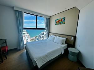 a hotel room with a bed and a large window at Mandala Hotel & Resort 5 Star in Mui Ne