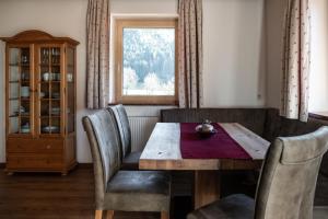 a dining room with a wooden table and chairs at Haus Alpenflora in Werfenweng