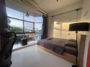 una camera da letto con un letto e una grande finestra di Blue Dream Hostel a Chiang Mai