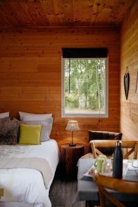 - une chambre avec 2 lits et une fenêtre dans une cabane en rondins dans l'établissement Le Clos De La Roche, à Goven 33 autres photos