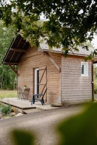 un petit bâtiment avec une table et des chaises sur une véranda dans l'établissement Le Clos De La Roche, à Goven