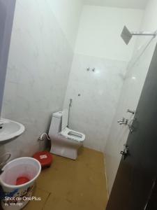 a small bathroom with a toilet and a sink at Om Baikunth Dham in Vrindāvan