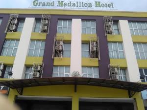 a hotel with a yellow and purple building at Grand Medallion Hotel in Kampong Tabuan