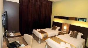 Kampong Sungai KantanUptown Imperial Kajang的酒店客房配有两张床和一张带笔记本电脑的书桌 更多21张照片