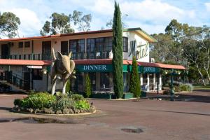 a statue of a cow in front of a building at Bandicoot Motor Inn Hamilton in Hamilton