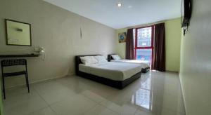 a bedroom with a bed and a chair and a window at Parc Hotel Pelangi Damansara in Kota Damansara