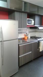 a kitchen with a refrigerator and a microwave at Apartamento En Sabaneta in Sabaneta