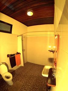 a bathroom with a toilet and a sink at Lumbalumba Resort - Manado in Manado