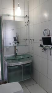 a bathroom with a sink and a mirror and a toilet at Residencial Adam Lima in Belém