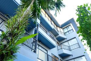 a building with blue trim and palm trees at The Umbrella House in Kamala Beach
