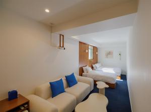 ein Hotelzimmer mit einer Couch und einem Bett in der Unterkunft Blue Mansion Seoul in Seoul