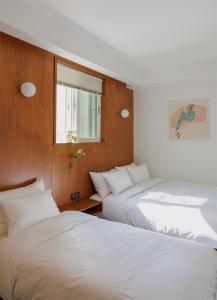 zwei Betten nebeneinander in einem Zimmer in der Unterkunft Blue Mansion Seoul in Seoul