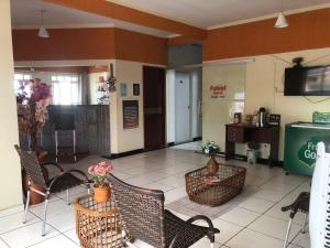 a lobby with chairs and a table and a tv at Fabiel Palace Hotel in Cuiabá