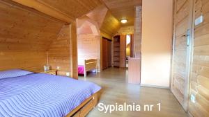 a bedroom in a wooden house with a bed at Wiślany Raj in Wisła