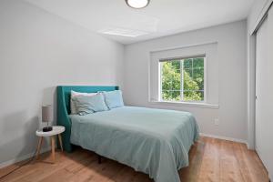 ein weißes Schlafzimmer mit einem Bett und einem Fenster in der Unterkunft Redmond Rest in Redmond