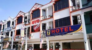 a hotel building with a hotel sign in front of it at Super OYO 635 Seven Days Hotel in Kampong Sempalit Hilir