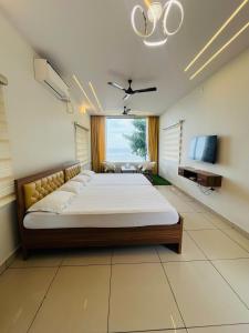 MalpeBeach Escape - Malpe Beach的一间带大床和电视的卧室