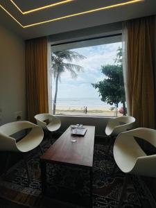 MalpeBeach Escape - Malpe Beach的一间有桌子、椅子和大窗户的房间