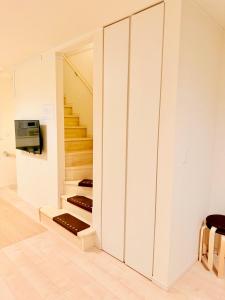 una stanza con pareti bianche e una scala di 池袋鑫の屋 a Tokyo