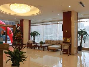 a lobby with a living room with a christmas tree at GreenTree Inn JinDeZhen People Square Taoxichuan Wenchuang Street in Jingdezhen