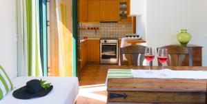 una cocina con mesa y 2 copas de vino en Villa Arsinoi, en Sissi