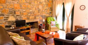 sala de estar con pared de piedra en Villa Arsinoi, en Sissi