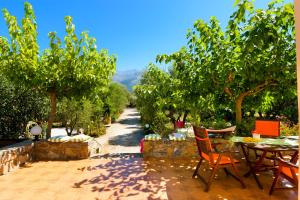 un patio con mesa, sillas y árboles en Villa Arsinoi, en Sissi