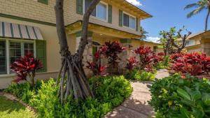 een huis met rode bloemen in de voortuin bij Ocean View in Koolina Oasis in Honokai Hale +20 foto's