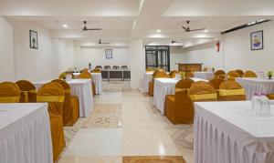 a banquet hall with white tables and yellow chairs at Treebo Executive Suites in Gandhinagar