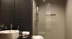 a bathroom with a shower and a sink and a sink at INBED in Sadao