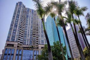 Liyuan Hotel في شنجن: مجموعة من أشجار النخيل أمام مبنى كبير