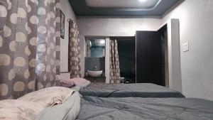 a bedroom with two beds and a bathroom with a sink at Cherry On The Top Homestay with AC in one bedroom in Kolhapur