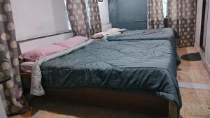 two twin beds in a room with curtains at Cherry On The Top Homestay with AC in one bedroom in Kolhapur