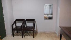 a table and two chairs in a room at Cherry On The Top Homestay with AC in one bedroom in Kolhapur