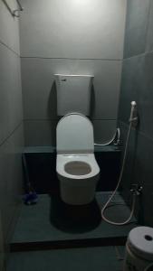 a small bathroom with a toilet with a hose at Cherry On The Top Homestay with AC in one bedroom in Kolhapur +2 photos