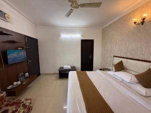 a hotel room with a bed and a tv at HolidayVilla - 1st Japanese Pod, Rooms & Suites - Green Avenue Amritsar in Amritsar