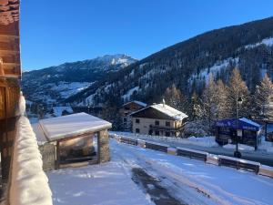 eine schneebedeckte Straße mit einem Gebäude und einem Berg in der Unterkunft Appartement centre Vars les Claux 150 m des pistes in Vars