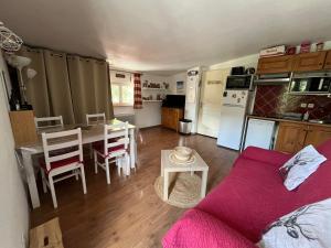 eine Küche und ein Wohnzimmer mit einer Couch und einem Tisch in der Unterkunft Appartement centre Vars les Claux 150 m des pistes in Vars