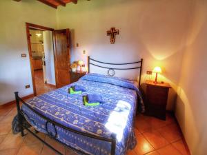 Castel FocognanoRustic Holiday Home in Ortignano with Swimming Pool的卧室里有一张床，墙上挂着一个十字架