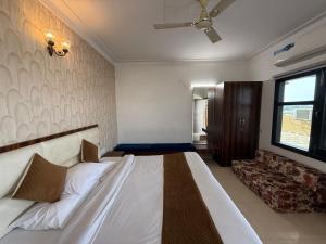 a bedroom with a large bed and a couch at HolidayVilla - 1st Japanese Pod, Rooms & Suites - Green Avenue Amritsar in Amritsar