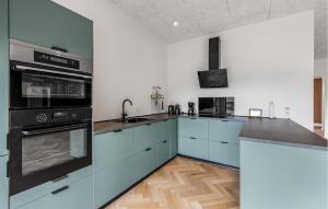 a large kitchen with blue cabinets and appliances at Awesome Home In Toftlund With Wifi in Arrild