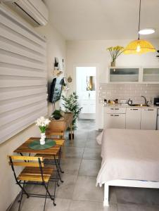 a bedroom with a bed and a table and a kitchen at Dekel Dom Baharava in Beʼer Ora